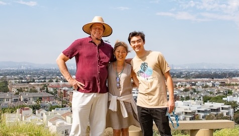 Two parents posing with their child who attends LMU